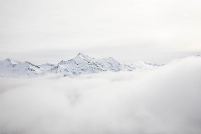 在白天的山脉覆盖着雪和云
